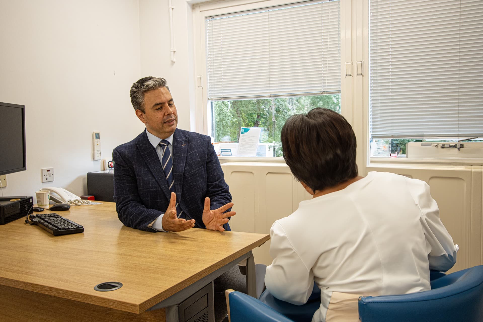 Mr Najib Daulatzai speaking with a patient during a consultation appointment in London or Hertfordshire
