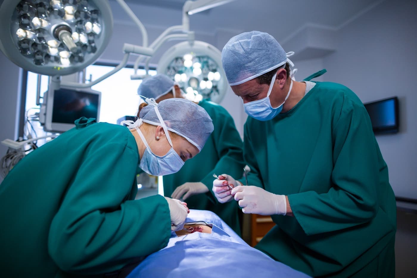 Surgeons performing an abdominal operation in theatre