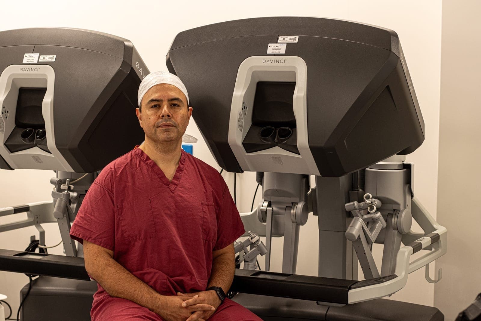 Mr Najib Daulatzai seated beside da Vinci robotic surgical systems used for advanced colorectal procedures